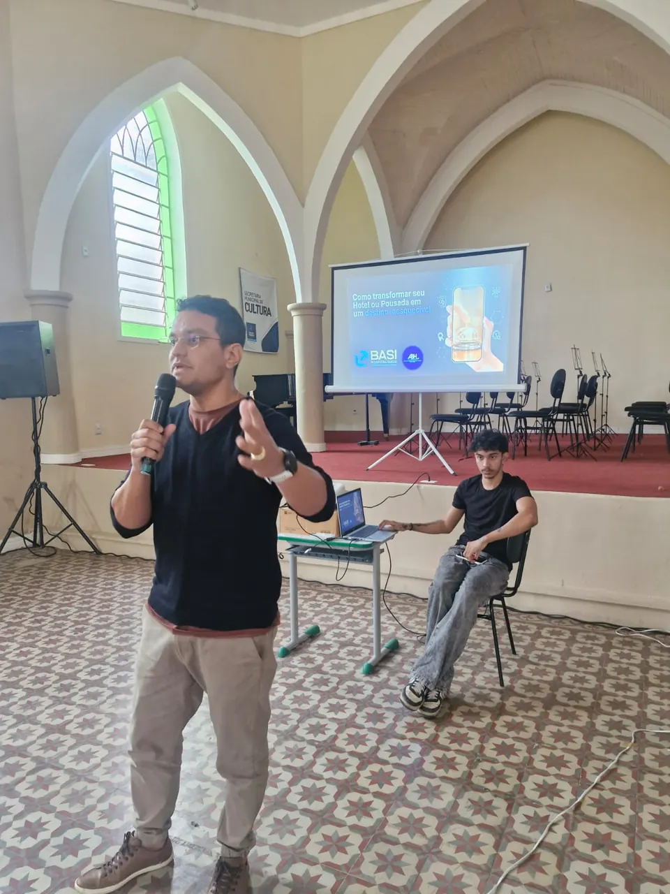 Palestrante apresentando o conteúdo, com moderador sentado ao lado