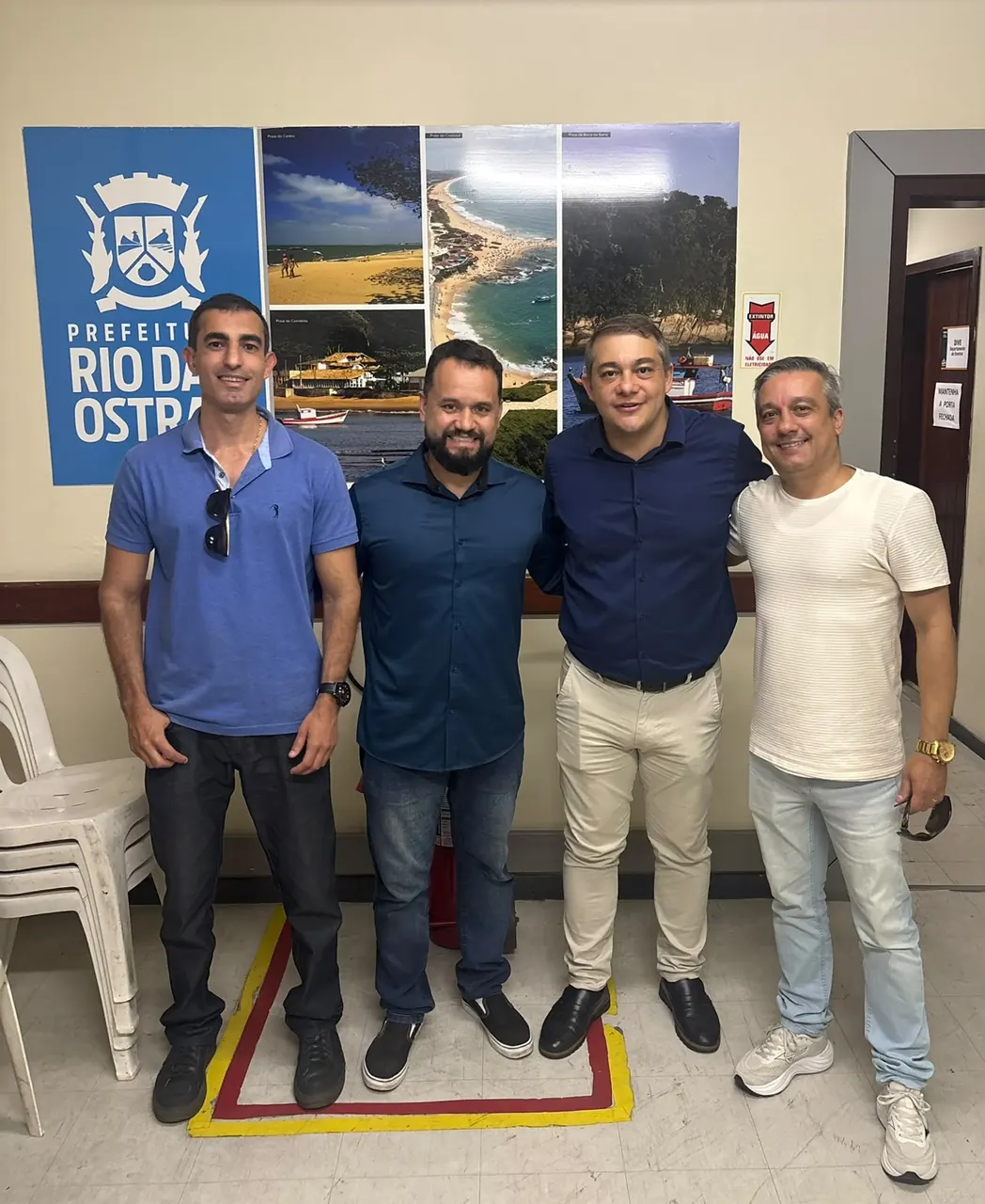 Representantes institucionais reunidos diante do painel da Prefeitura de Rio das Ostras