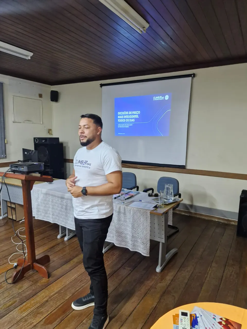 Palestrante apresentando o conteúdo ao lado da projeção